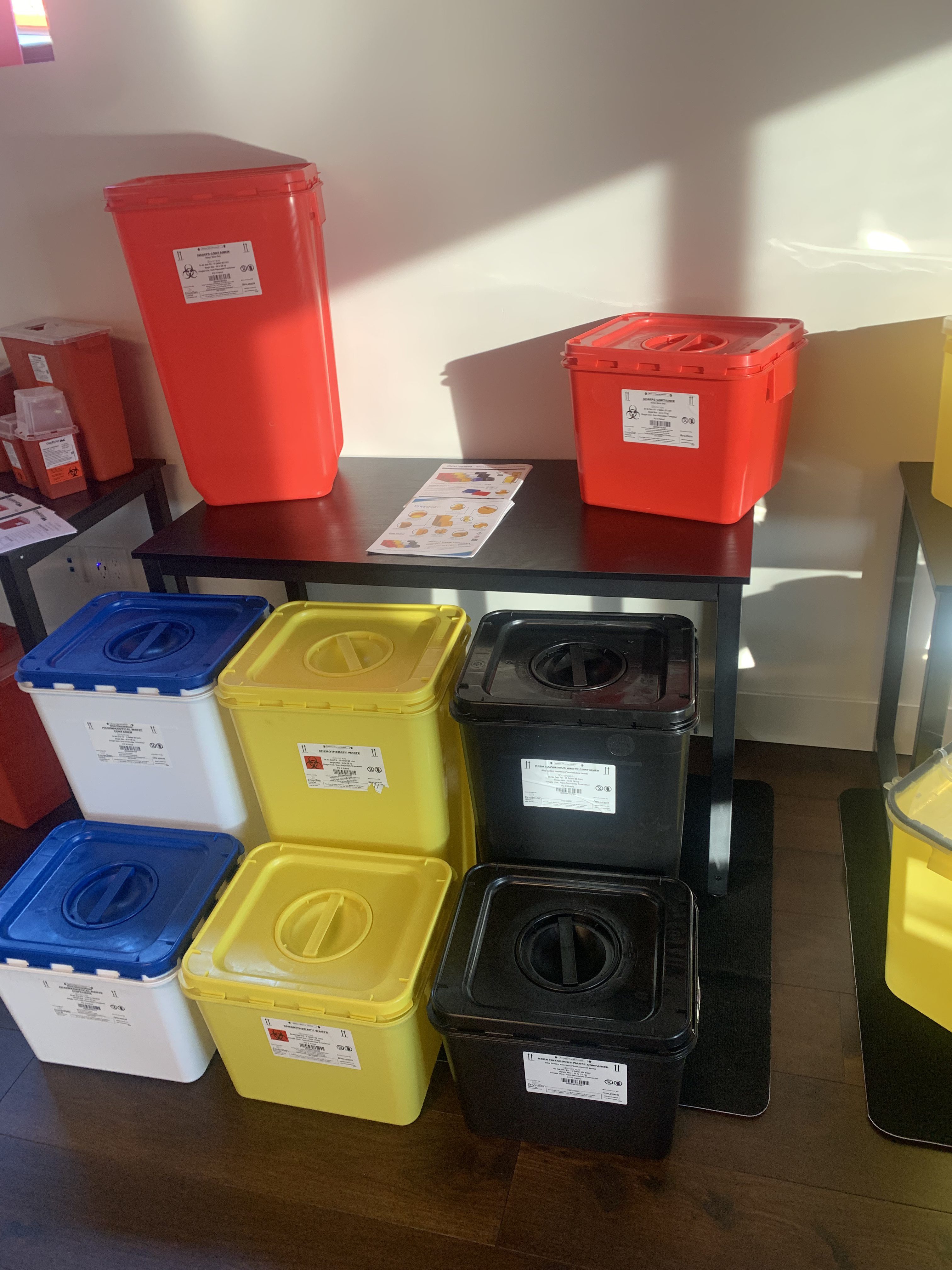 MedXWaste trade show display with biohazard containers and company brochures