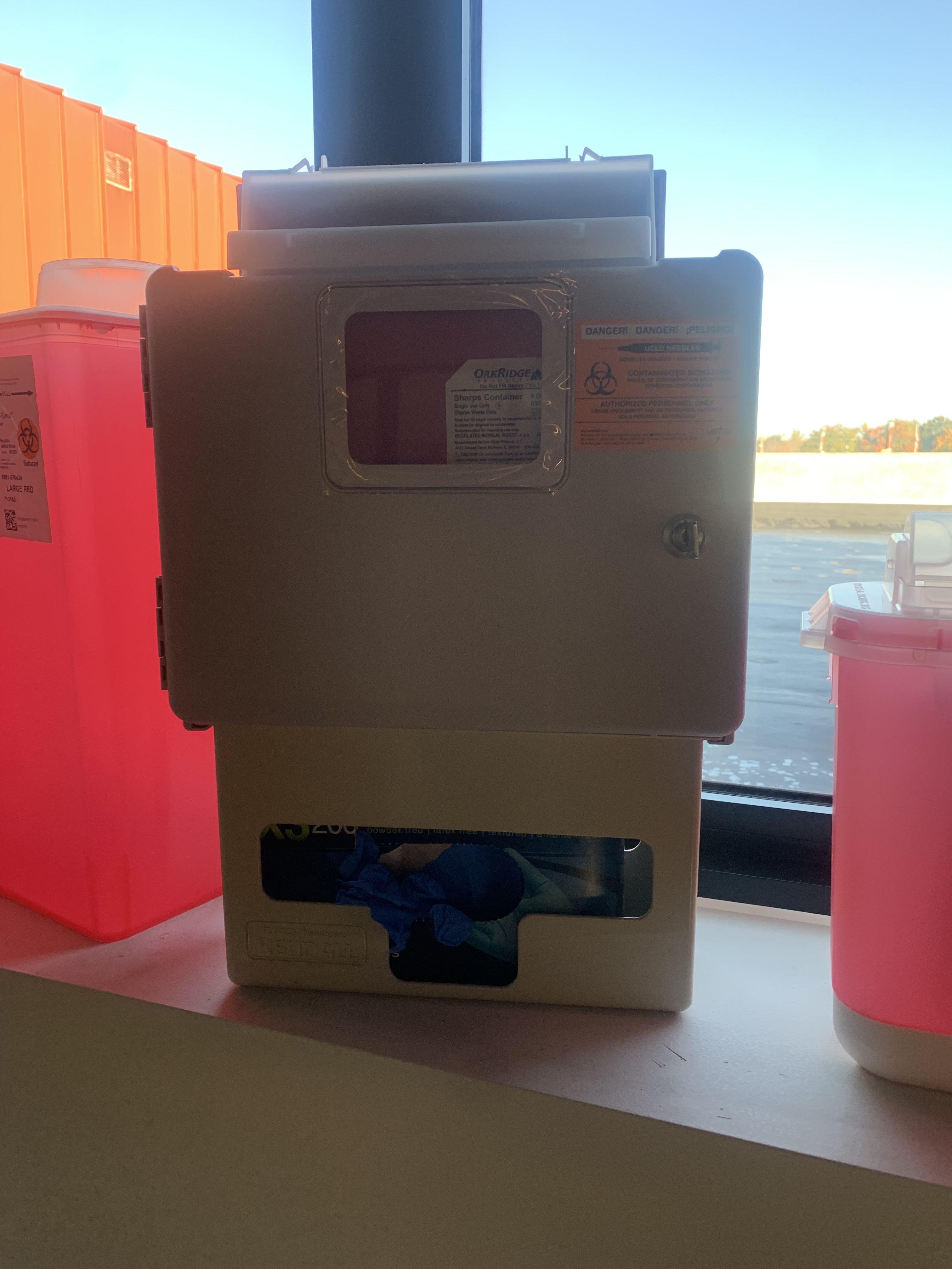 MedXWaste trade show table setup with sharps containers and compliance brochures
